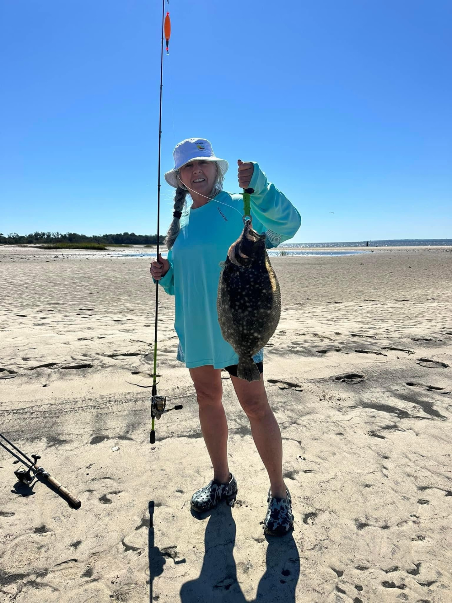 Founder of Aqua Marine Customs holding a flounder on a South Carolina beach